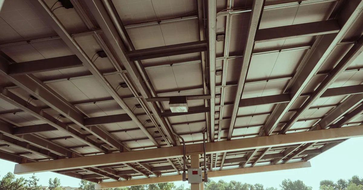 Carport solaire photovoltaïque abritant une voiture électrique en charge
