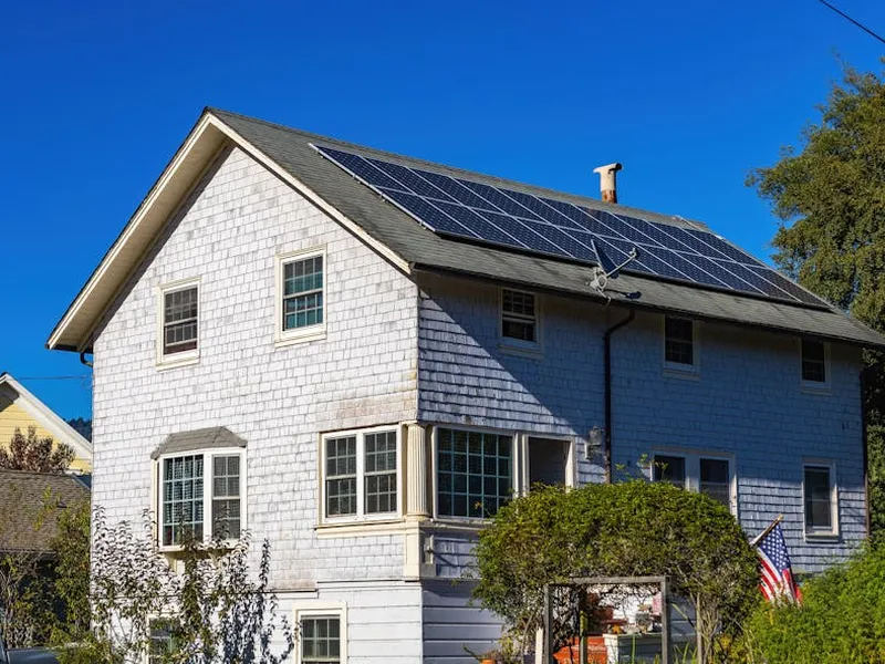 Installateur RGE QualiPV pose un panneau solaire sur un toit à Bourgogne