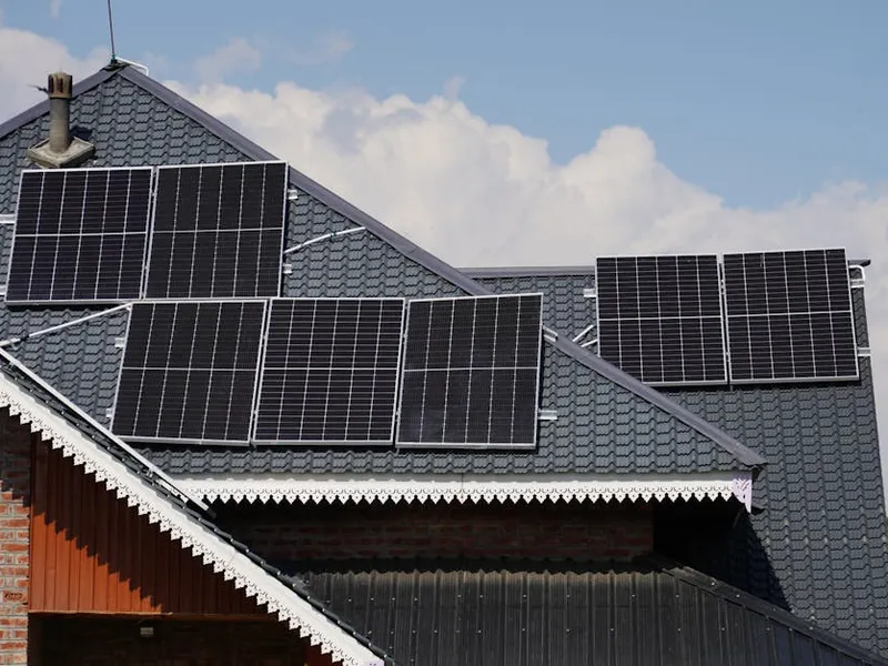 Installateur RGE QualiPV pose un panneau solaire sur un toit à Grenoble