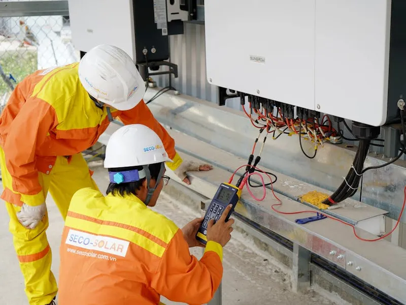 Micro-onduleur Enphase installé sous un panneau solaire sur toit